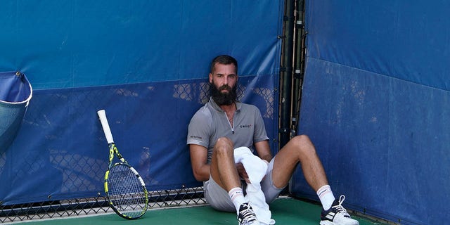 France's Benoit Paire sits on the court during his match against Britain's Cameron Norrie as first responders attend to a medical emergency in the stands at the 2022 U.S. Open at the USTA Billie Jean King National Tennis Center in New York Aug. 30, 2022.