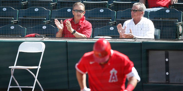 Los Angeles Angels owner Arte Moreno, left, applauds as Mike Trout steps up to bat against the San Francisco Giants during the third inning of a spring training game at Tempe Diablo Stadium March 11, 2021, in Tempe, Ariz. 