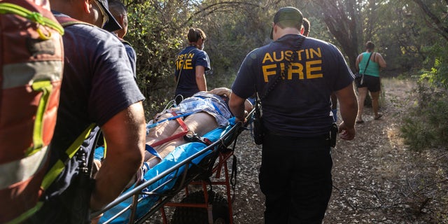 Austin Fire Department medics rescue a woman after she collapsed in the heat while on a hiking trail on Aug. 2, 2022, in Austin, Texas.