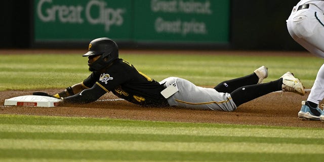 Rodolfo Castro of the Pittsburgh Pirates slides into third base as his cellphone falls out of his pocket at Chase Field on Aug. 9, 2022, in Phoenix, Arizona. 