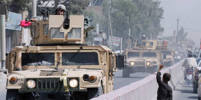 An Afghan boy waves to a NATO forces convoy patrolling in Kandahar on Aug. 15, 2009.