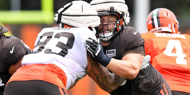 Joel Bitonio of the Cleveland Browns, center, blocks teammate Tommy Togiai (93) during Browns training camp at CrossCountry Mortgage Campus on Aug. 9, 2022, in Berea, Ohio.