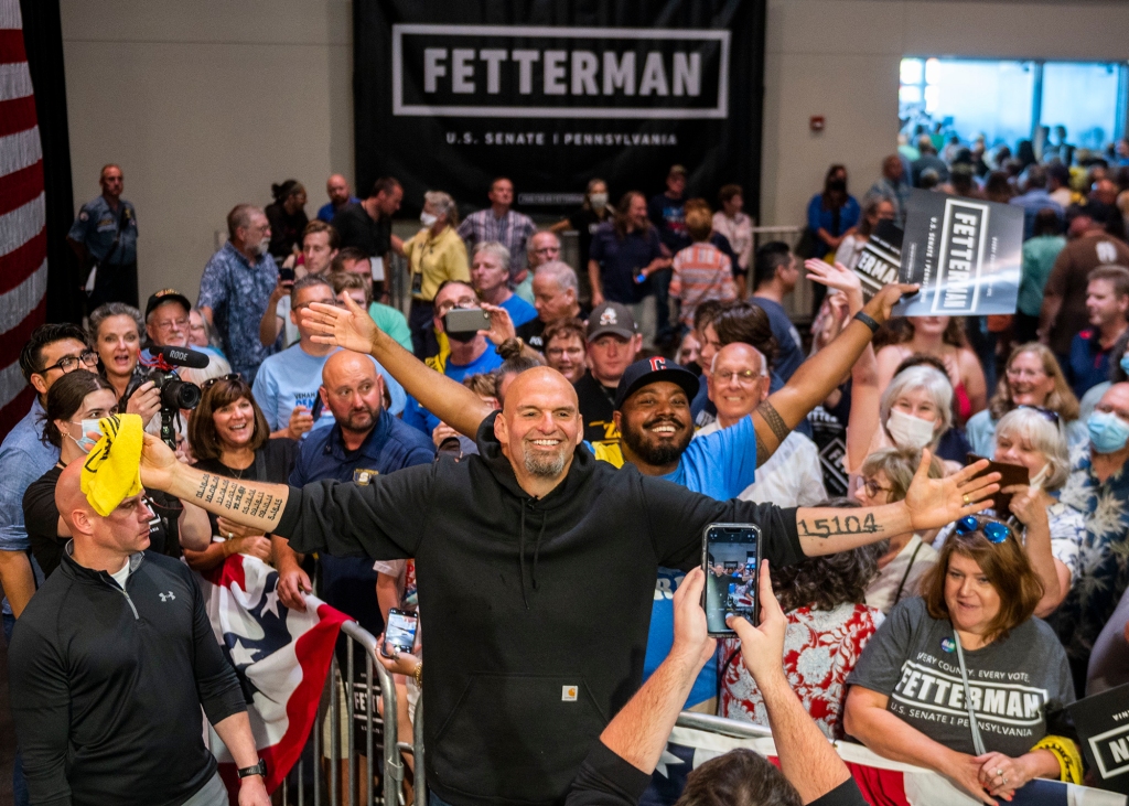 Fetterman celebrates after his first public appearance since his stroke. His left arm is inked with the number 15104 – Braddock’s ZIP code. His right arm is etched with the dates of the nine murders that happened in the town while he was mayor.