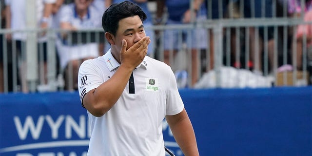 Joohyoung Kim, right, of South Korea, reacts after winning the Wyndham Championship golf tournament in Greensboro, N.C., Sunday, Aug. 7, 2022. 