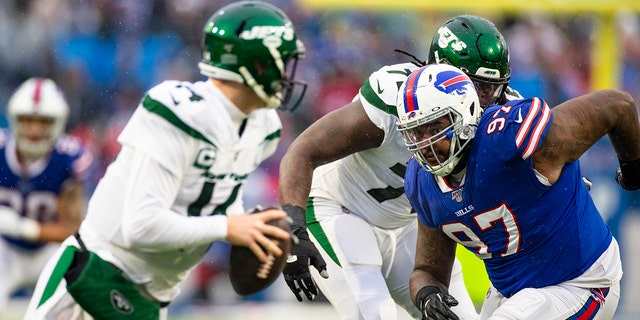 Jordan Phillips, #97 of the Buffalo Bills, pushes past Brandon Shell, #72, towards Sam Darnold, #14 of the New York Jets, during the first quarter at New Era Field on December 29, 2019 in Orchard Park, New York. New York defeats Buffalo 13-6.