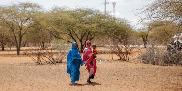 Women walk towards an open-air market in the village of Wagalla in northern Kenya Friday, Aug. 19, 2022. 