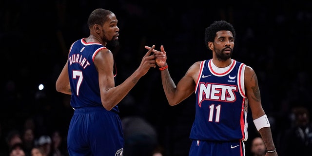 Brooklyn Nets' Kyrie Irving and Kevin Durant celebrate after a basket against the Indiana Pacers at the Barclays Center, April 10, 2022, in New York. 