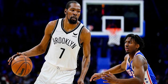 Brooklyn Nets' Kevin Durant, left, dribbles past Philadelphia 76ers' Tyrese Maxey, March 10, 2022, in Philadelphia.