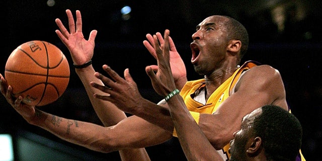 Los Angeles Lakers' Kobe Bryant goes up for a shot between the Boston Celtics' Paul Pierce, left, and Al Jefferson during the first half of an NBA basketball game in Los Angeles. (AP Photo/Branimir Kvartuc, File)