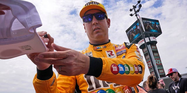 Kyle Busch gives an autograph during driver introductions prior to a NASCAR Cup Series auto race at Richmond Raceway, Sunday, Aug. 14, 2022, in Richmond, Virginia.