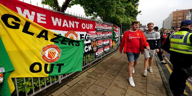 Fans walk to the Old Trafford ground, Manchester, England, Monday Aug. 22, 2022, ahead of an organised protest against the Manchester United owners before the Premier League match between Manchester United and Liverpool.