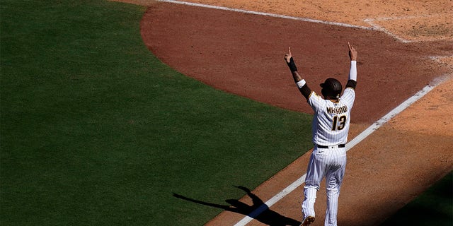 San Diego Padres' Manny Machado reacts as he scores from third off a three-run home run hit by Brandon Drury during the sixth inning of a baseball game against the San Francisco Giants, Wednesday, Aug. 10, 2022, in San Diego. (AP Photo/Gregory Bull)