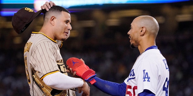 San Diego Padres third baseman Manny Machado, left, and Los Angeles Dodgers' Mookie Betts chat during the fifth inning of a baseball game Saturday, Aug. 6, 2022, in Los Angeles.