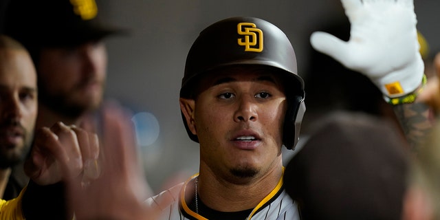 The San Diego Padres' Manny Machado  is congratulated by teammates after his home run during the fourth inning of a game against the Miami Marlins May 5, 2022, in San Diego. 