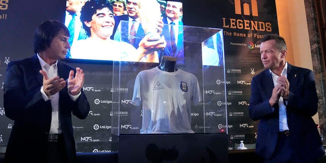 Former German soccer player Lothar Matthaus, right and Argentine collector and President of the Legends football museum Marcelo Ordas, applaud as the shirt worn by Diego Armando Maradona in the final of the 1986 World Cup in Mexico is unveiled, during an event at the Argentine Embassy in Madrid, Spain, Thursday Aug. 25, 2022.