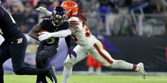 Marquise Brown #5 of the Baltimore Ravens is tackled by Ronnie Harrison Jr. #33 of the Cleveland Browns during a game  at M&amp;amp;T Bank Stadium on Nov. 28, 2021 in Baltimore, Maryland. 