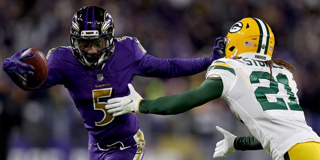 Marquise Brown #5 of the Baltimore Ravens runs with the ball after the catch against Eric Stokes #21 of the Green Bay Packers in the fourth quarter at M&amp;amp;T Bank Stadium on December 19, 2021 in Baltimore, Maryland. 