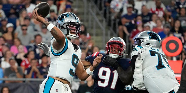 Carolina Panthers quarterback Matt Corral passes under pressure from New England Patriots defensive end Deatrich Wise Jr., Friday, Aug. 19, 2022, in Foxborough, Massachusetts.