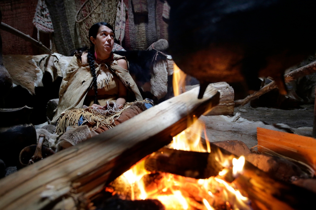 Mashpee Wampanoag Kerri Helme, of Fairhaven, Mass., uses plant fiber to weave a basket while sitting next to a fire on November 15, 2018, at the Wampanoag Homesite at the Plimoth Patuxet Museums, in Plymouth.