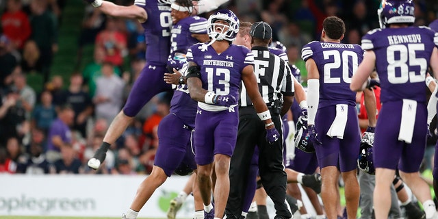 Northwestern players celebrate after an interception during the second half of an NCAA college football game against Nebraska, Saturday, Aug. 27, 2022, at Aviva Stadium in Dublin, Ireland. Northwestern won 31-28.