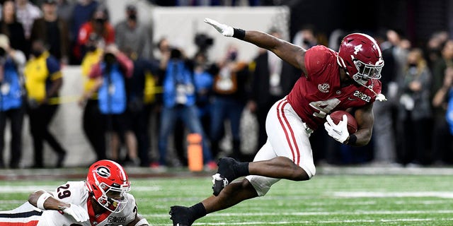 INDIANAPOLIS, IN - JANUARY 10: Georgia Bulldogs DB Christopher Smith (29) trips Alabama Crimson Tide RB Brian Robinson Jr. (4) during the Alabama Crimson Tide versus the Georgia Bulldogs in the College Football Playoff National Championship, on January 10, 2022, at Lucas Oil Stadium in Indianapolis, IN. 