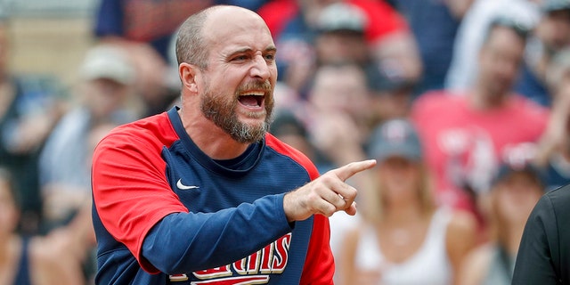 Minnesota Twins manager Rocco Baldelli, right, argues with umpires after a review reversed a call that originally had Toronto Blue Jays' Whit Merrifield out at home in the 10th inning, Sunday, Aug. 7, 2022, in Minneapolis.