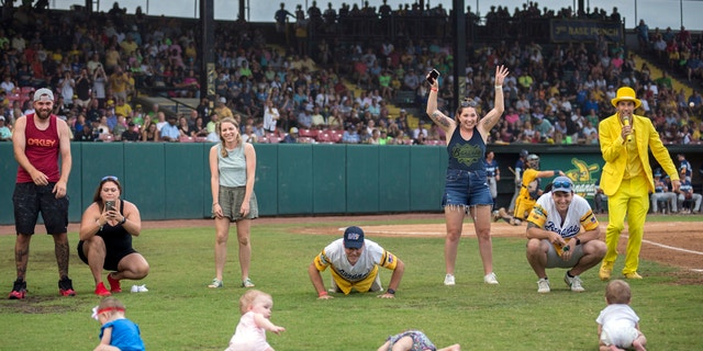 FILE - Four infants and their parents take part in what the Savannah Bananas call The Slowest Race, at the team's baseball game against the Wilmington Sharks, Saturday, June 11, 2022, in Savannah, Ga.