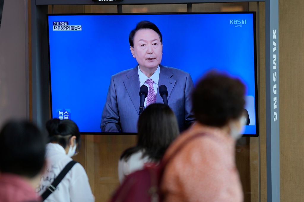 People watch a TV screen showing a live broadcast of South Korean President Yoon Suk Yeol's in Seoul on August 17, 2022.