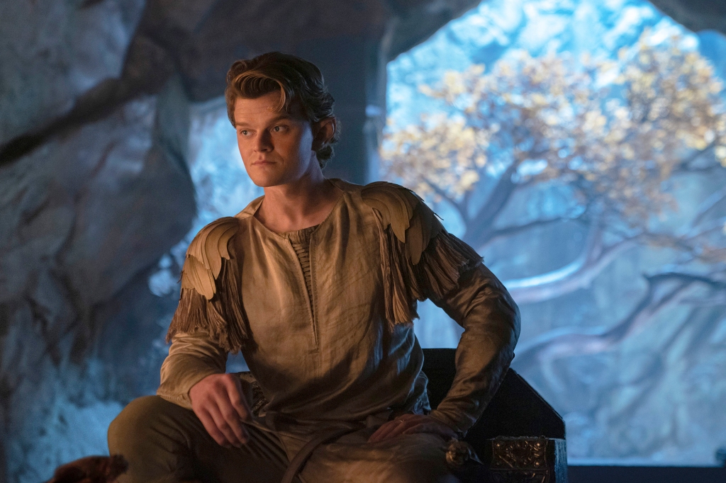 Elrond (Robert Aramayo) sitting next to a tree in "The Rings of Power." 