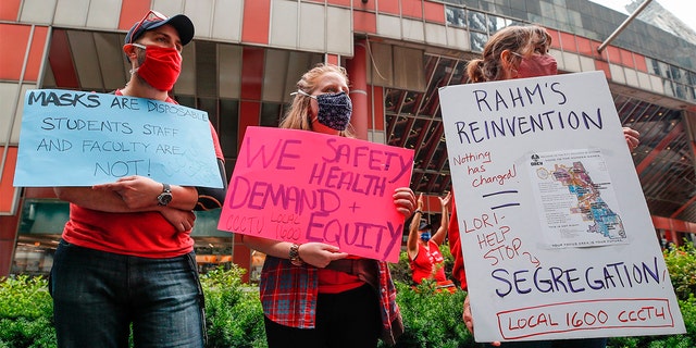 Protesters hold signs during the Occupy City Hall Protest and Car Caravan hosted by the Chicago Teachers Union in Chicago, Illinois, on Aug. 3, 2020.