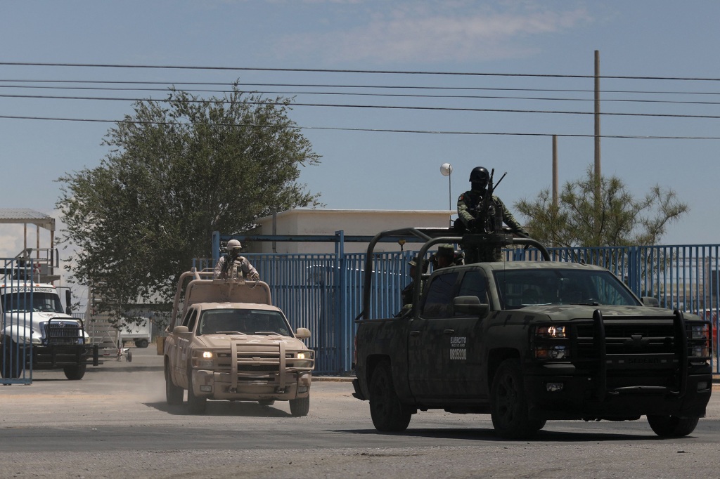 Mexican Army riding on trucks.