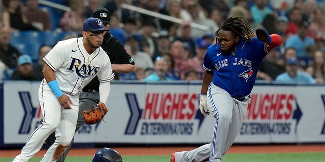 Toronto Blue Jays' Vladimir Guerrero Jr., right, steals third base as Tampa Bay Rays third baseman Isaac Paredes fields a wide throw during the third inning of a baseball game Tuesday, Aug. 2, 2022, in St. Petersburg, Fla. 