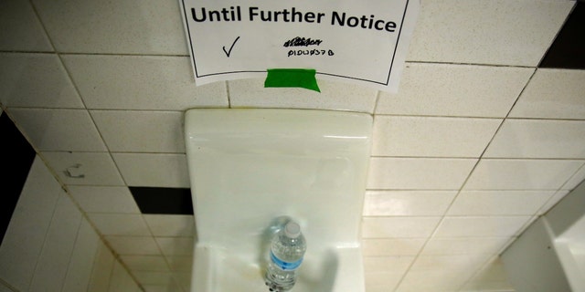 A sign is seen next to a water dispenser at North Western High School in Flint, a city struggling with the effects of lead-poisoned drinking water in Michigan, May 4, 2016. 