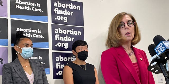 Oregon Gov. Kate Brown speaks at a Planned Parenthood clinic in Portland on Aug. 25, 2022. Oregon Democratic state representative Andrea Valderrama, left, and Planned Parenthood Advocates for Oregon’s executive director An Do, back center, said Oregon will welcome out-of-state patients seeking abortion care. 