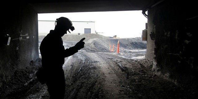 In this Nov. 9, 2010 file photo, a mine employee stands in the entry of the Signal Peak Energy's Bull Mountain mine in Roundup, Montana.