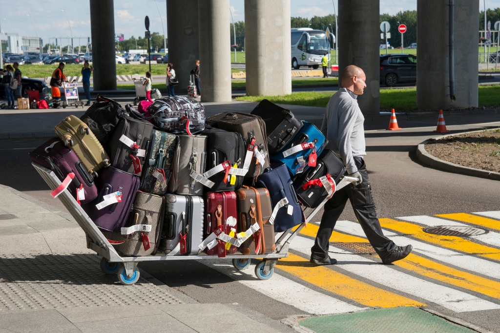 Man pulling cart of luggage.