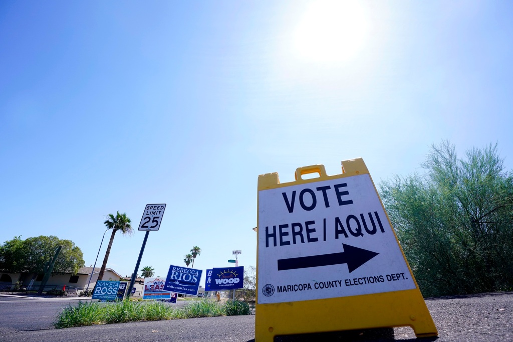 A where to vote sign points voters in the direction of the polling station as the sun beats down as Arizona voters go the polls to cast their ballots, Tuesday, Aug. 2, 2022, in Phoenix. (AP Photo/Ross D. Franklin)