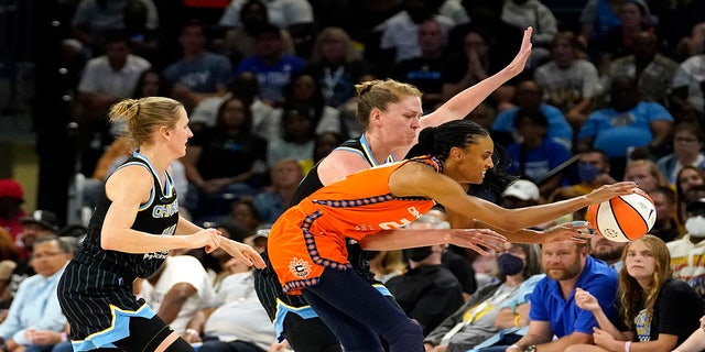 Connecticut Sun's DeWanna Bonner (24) keeps the ball from going out of bounds as Chicago Sky's Allie Quigley, left, and Emma Meesseman defend during the second half in Game 1 of a WNBA basketball semifinal playoff series Sunday, Aug. 28, 2022, in Chicago. The Sun won 68-63.