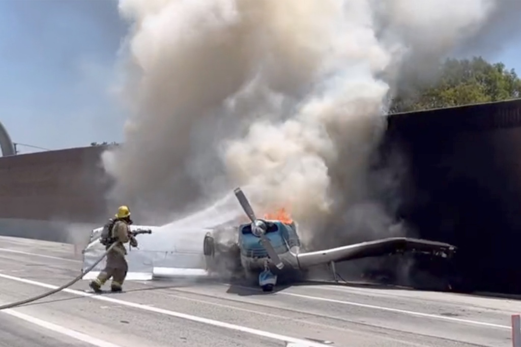 A Corona firefighter douses the flames of the small aircraft.