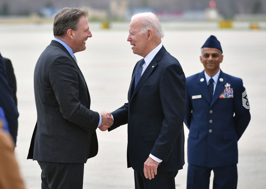 Governor of New Hampshire Chris Sununu (left) greets President Biden ( right) upon arrival at Portsmouth International Airport at Pease in Portsmouth, New Hampshire.