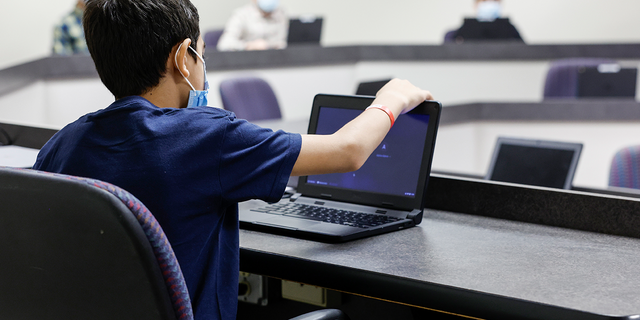 A young Afghan boy looks at a laptop in a computer classroom in the National Conference Center (NCC), which in recent months has been redesigned to temporarily house Afghan nationals on August 11, 2022 in Leesburg, Virginia. (Photo by Anna Moneymaker/Getty Images)