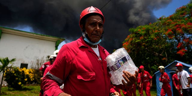 Members of the Cuban Red Cross prepare to head out to the Matanzas Supertanker Base, where firefighters were working to quell a blaze that began during a thunderstorm the night before, in Matanzas, Cuba, Aug. 6, 2022. (AP Photo/Ramon Espinosa)