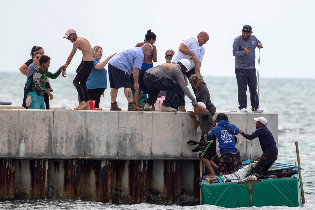 Residents help Cuban migrants to shore near Key West, Fla., Friday, Aug. 12, 2022. 