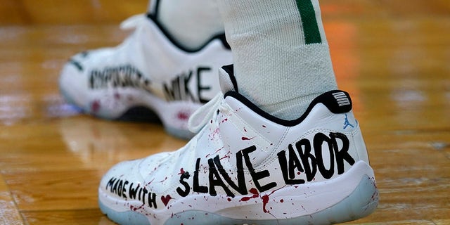 Boston Celtics center Enes Kanter displays a message on his shoes during the first half of an NBA basketball game against the Washington Wizards, Wednesday, Oct. 27, 2021, in Boston. 