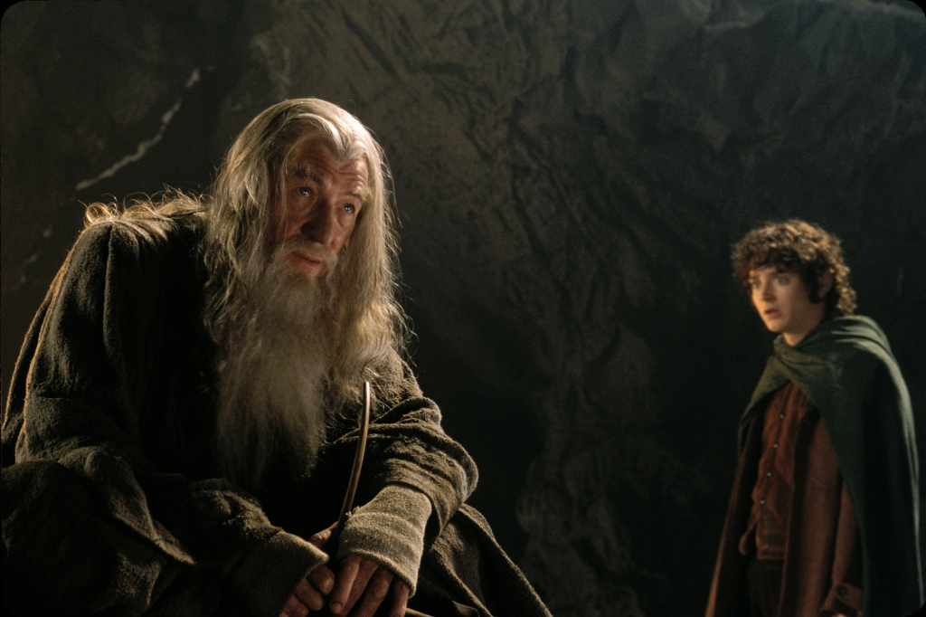Gandalf next to Frodo in a cave. 