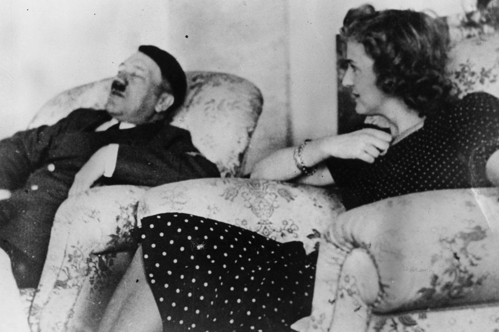 Hitler asleep in an armchair watched by his mistress Eva Braun.