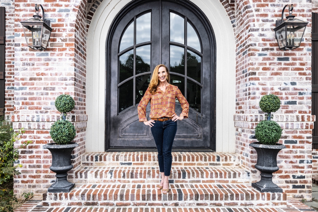 Rehder standing on a porch in front of a double door. 