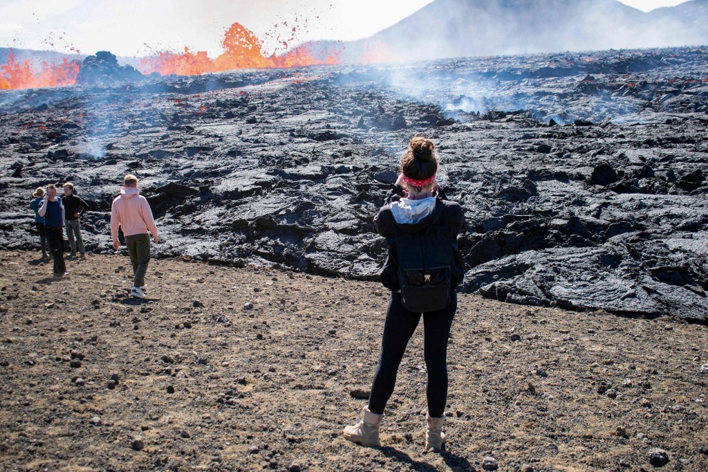 People visit the scene of the newly erupted volcano taking place in Meradalir valley, near mount Fagradalsfjall, Iceland on August 4, 2022.