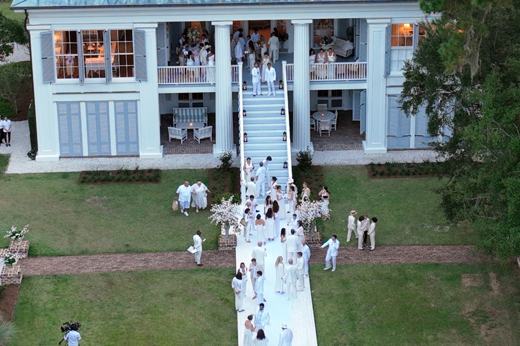 Guests all wearing white arrive to the cocktail reception.