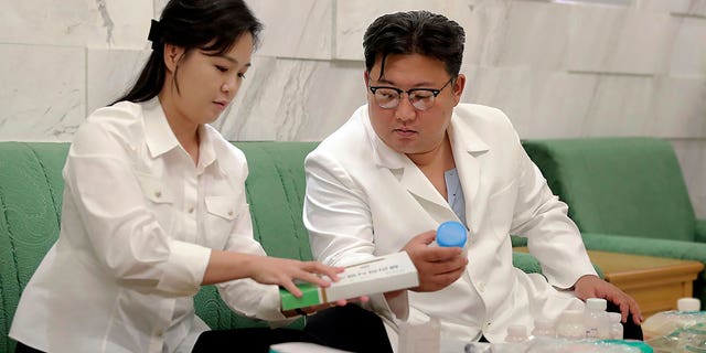 In this photo provided by the North Korean government, North Korean leader Kim Jong Un and his wife Ri Sol Ju prepare medicines at an unannounced place in North Korea Wednesday, June 15, 2022, to send them to Haeju City where an infectious disease occurred.